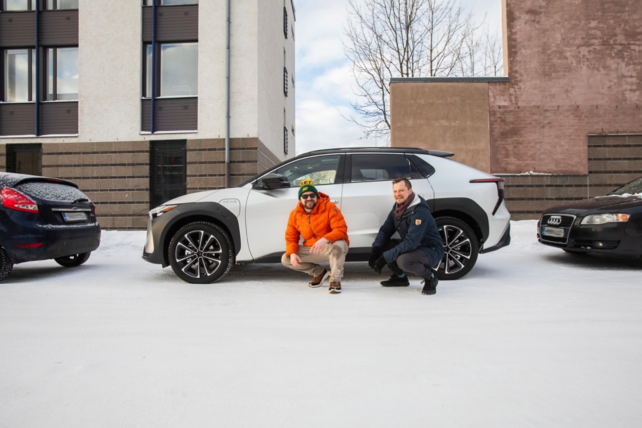 Sähköinen Toyota bZ4X taskuparkissa sekä amatöörikoeajaja Juho Paavola ja Lauri Muranen