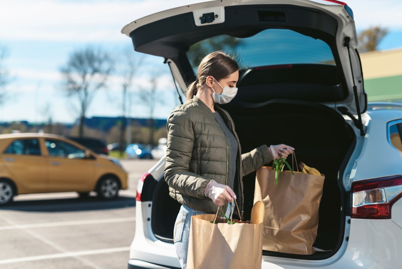 Nainen pakkaa ruokaostoksia autoon